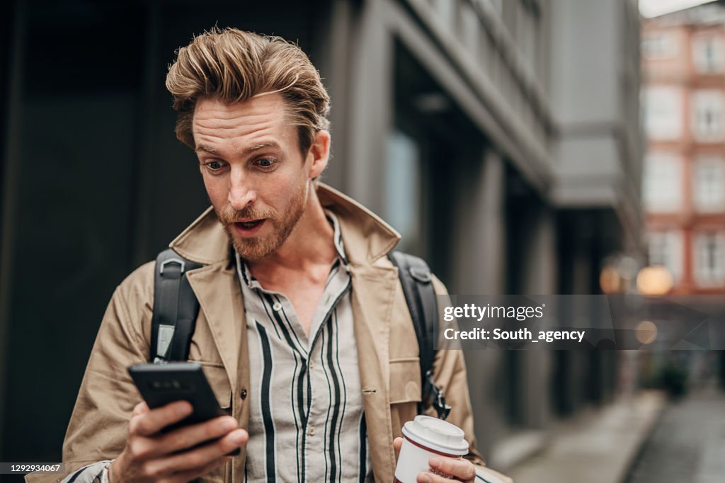 Verraste mens die telefoon op de straat in stad gebruikt