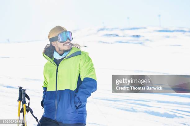 smiling man enjoying view from top of ski slope on sunny winter afternoon - ski pole stock pictures, royalty-free photos & images