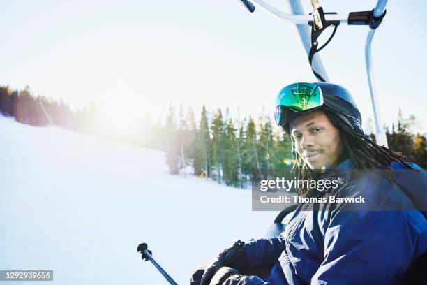 portrait of smiling male skier riding chairlift on winter afternoon - ski wear stock pictures, royalty-free photos & images