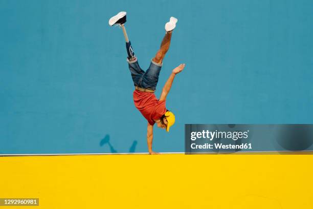 man practicing handstand on multi colored wall - prosthetic arm stock pictures, royalty-free photos & images