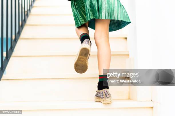 girl wearing green skirt running upstairs - girl rising stock-fotos und bilder