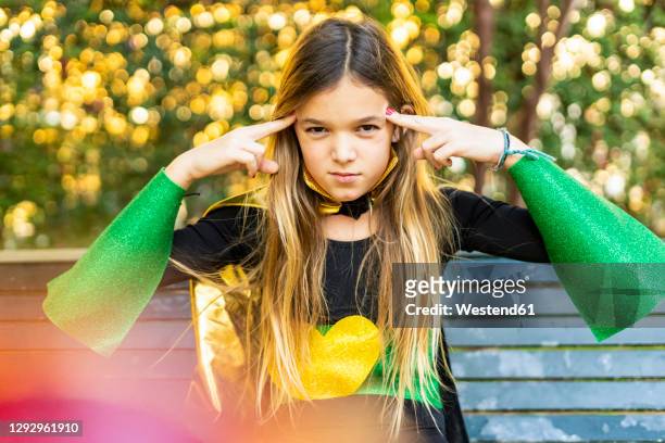 girl posing in super heroine costume on a bench - mind reading stock pictures, royalty-free photos & images