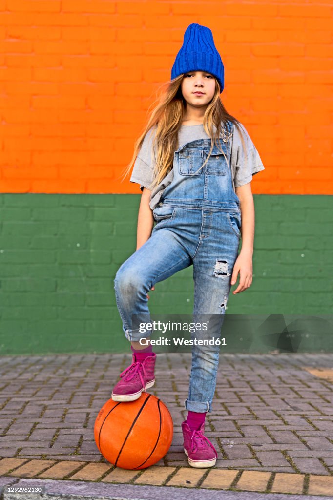 Young girl with foot on basketball