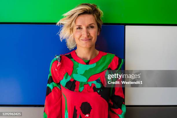 confident female cook in casuals against colorful wall at cooking school - woman cook foto e immagini stock