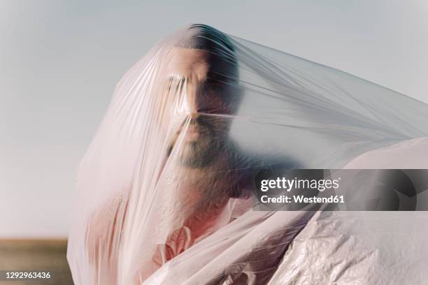 man trapped in a plastic foil - servidão imagens e fotografias de stock