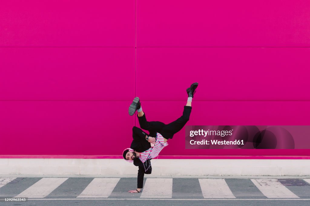 Young man listening to music and dancing breakdance