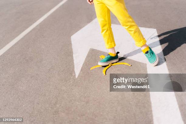girl stepping on banana peel on a street - go bananas stockfoto's en -beelden