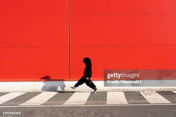 little girl wearing black fancy dress walking on zebra crossing - beenden stockfoto's en -beelden