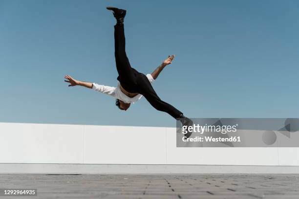 artist practising on roof terrace - akrobatik stock-fotos und bilder