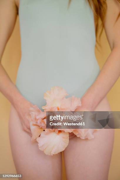 young woman with pink flower wearing pastel blue swiming suit - 女性生殖器 個照片及圖片檔