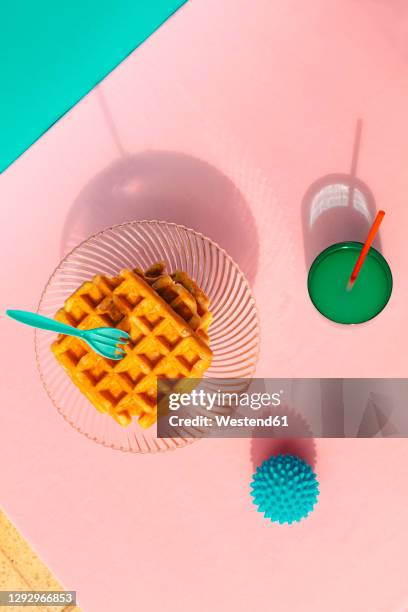 directly above view of waffle, juice, rubber ball kept on table - waffle stock-fotos und bilder