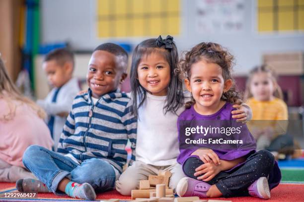 multi etnische kinderen die voor de camera stellen - preschool classroom stockfoto's en -beelden