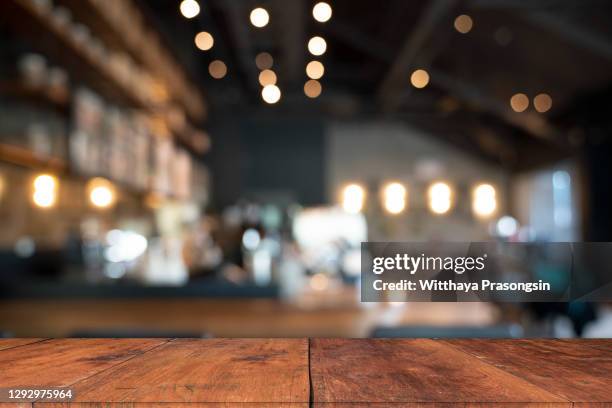 wood table top with blur of people in coffee shop or (cafe,restaurant )background - bistrot photos et images de collection