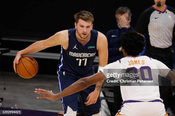 Luka Doncic of the Dallas Mavericks handles the ball against Damian Jones of the Phoenix Suns during the NBA game at PHX Arena on December 23, 2020...