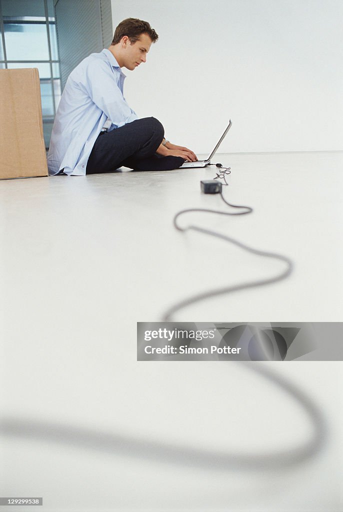 Businessman using laptop on floor