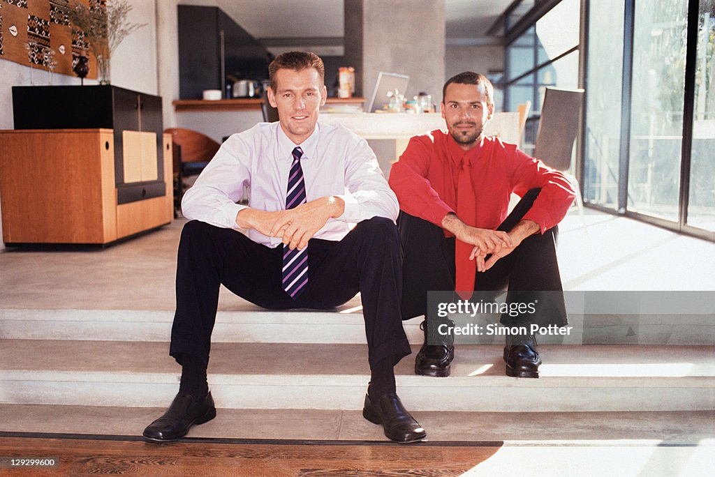 Businessmen sitting on steps together