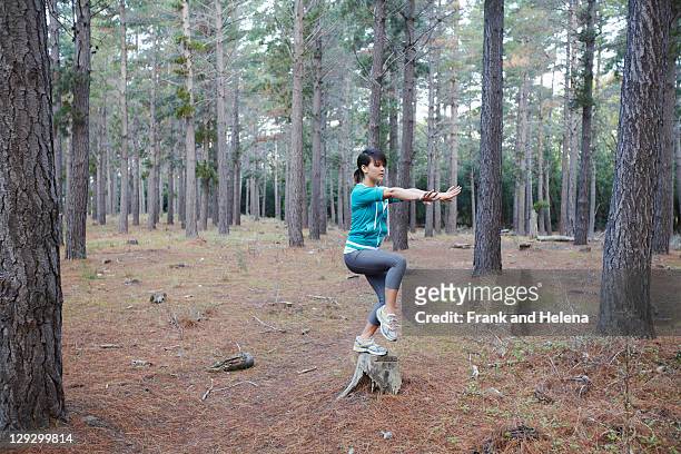 woman balancing on stump in forest - woman and tai chi stock pictures, royalty-free photos & images