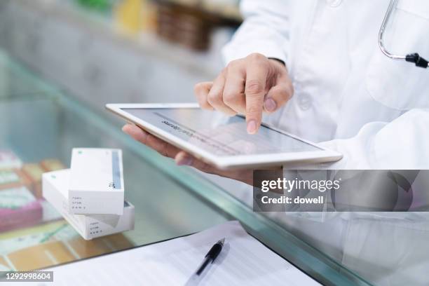 pharmacist with digital tablet - female pharmacist with a digital tablet stock-fotos und bilder