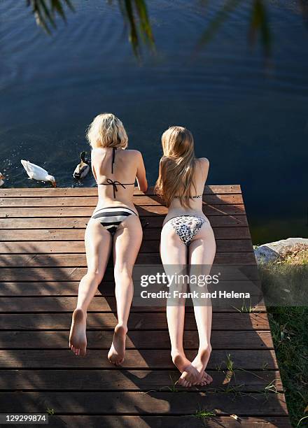 women in bikinis laying on deck - duck pier stock pictures, royalty-free photos & images