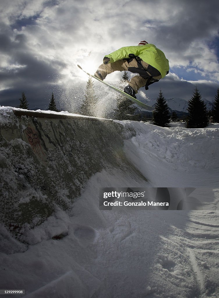Snowboarder jumping on half-pipe