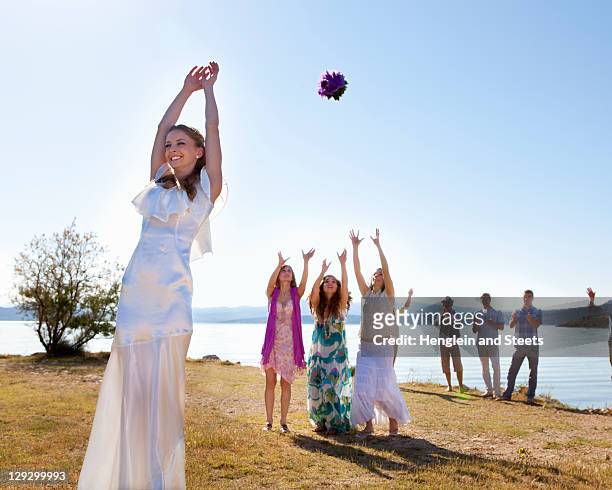 bride throwing bouquet to friends - catch 22 foto e immagini stock