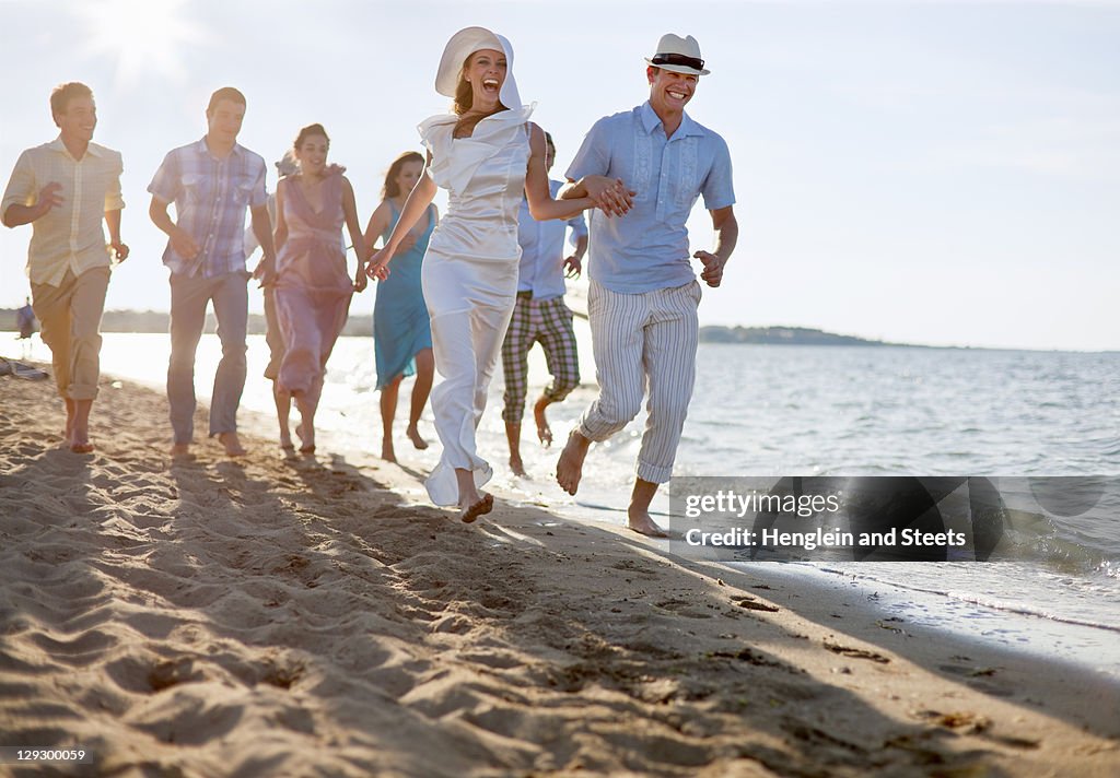 Newlywed couple on beach with friends