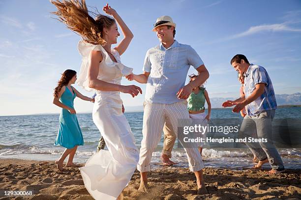 newlywed couple on beach with friends - party guest stock pictures, royalty-free photos & images