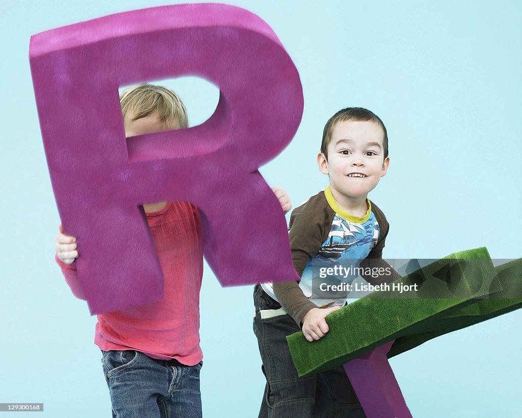 Toddlers playing with oversize letters