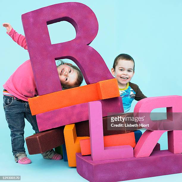 toddlers playing with oversize letters - best r stock pictures, royalty-free photos & images