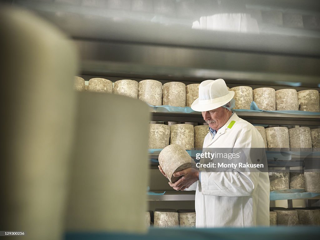 Head cheese-maker with blue cheese in cheese-making factory