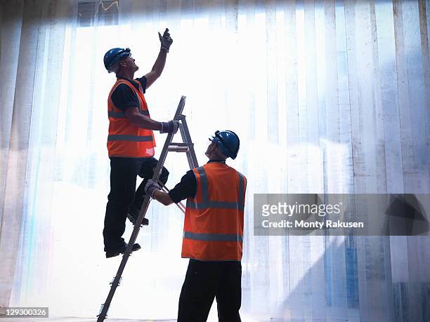 silhouette of workers with a step ladder - ladder stock pictures, royalty-free photos & images