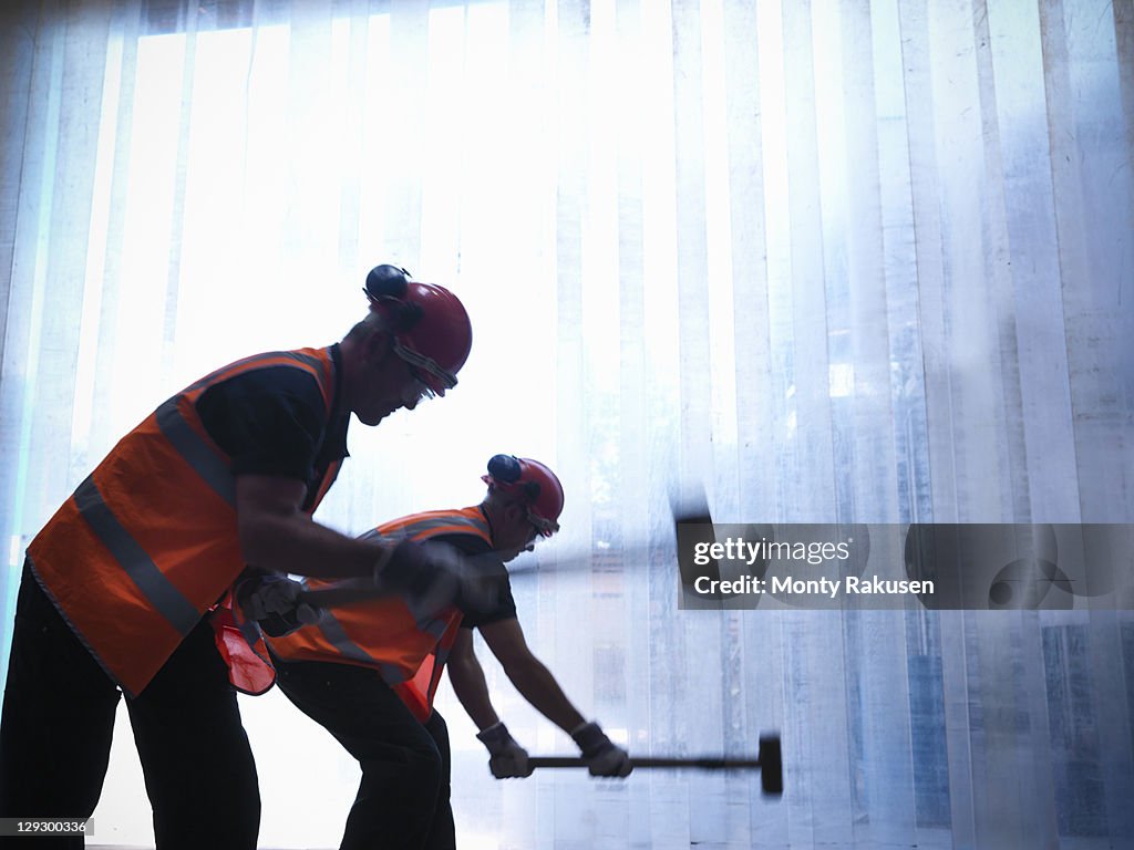 Silhouette of workers swinging hammers