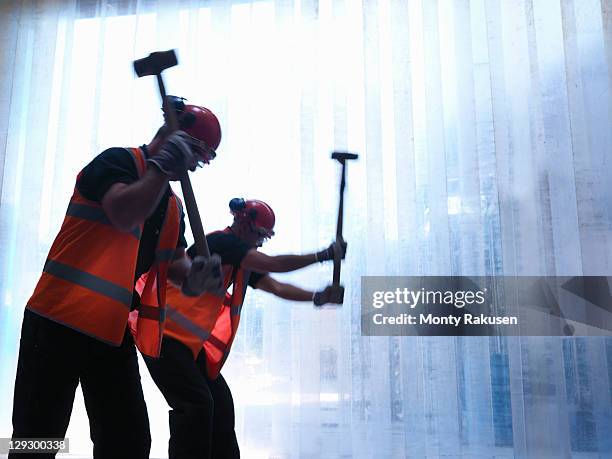 silhouette of workers swinging hammers - swinging sledgehammer stock pictures, royalty-free photos & images