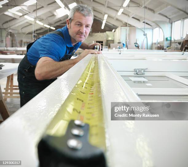 worker measuring window frame in joinery - tape measure stock pictures, royalty-free photos & images