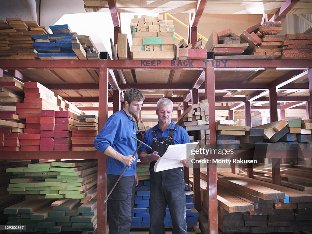 Workers in wood store in joinery