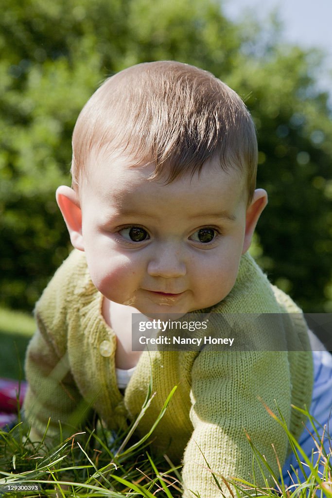 Baby boy crawling in grass