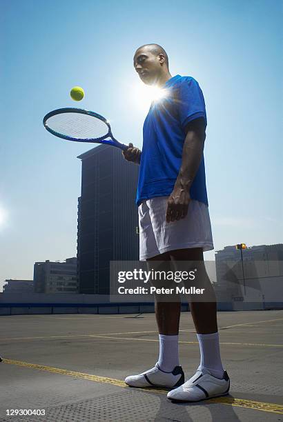 tennis player on rooftop court - bouncing stock pictures, royalty-free photos & images