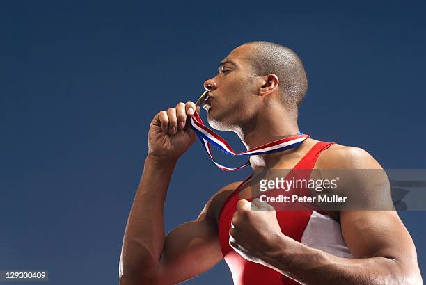 athlete kissing medal outdoors - medal stock pictures, royalty-free photos & images