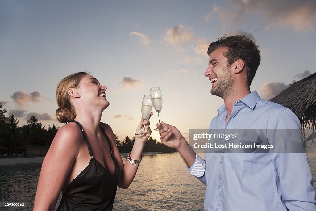 Couple toasting each other on dock