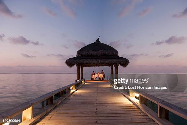couple eating on tropical dock - couple fine dining stock-fotos und bilder