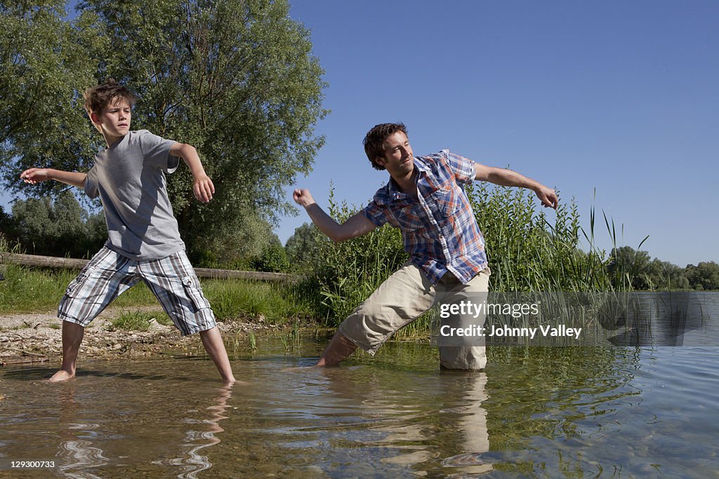 Padre e hijo omitir rocks on lake