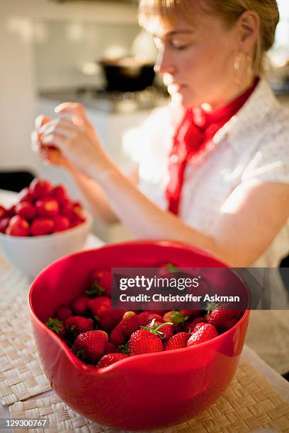 woman paring strawberries in kitchen - hørsholm stock pictures, royalty-free photos & images