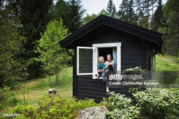girls sitting in window of shack - small stock pictures, royalty-free photos & images
