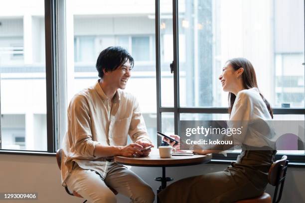 a couple having a fun conversation at a cafe - coffee shop couple stock pictures, royalty-free photos & images