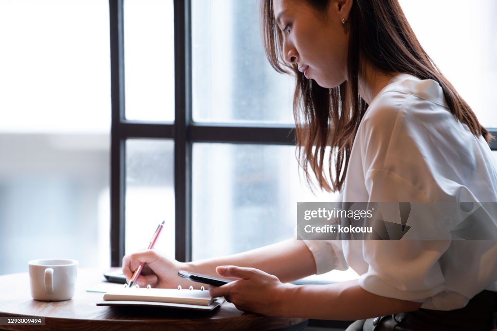 カフェでリモートワークをしている女性