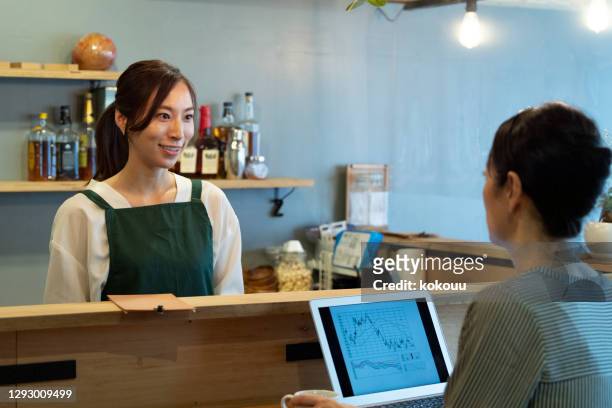 a female clerk at a cafe and a female customer are having a fun conversation - only japanese stock pictures, royalty-free photos & images