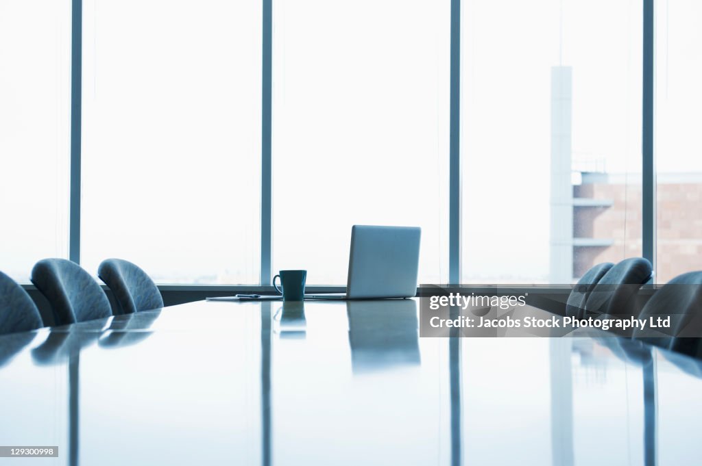 Laptop and coffee cup on conference room table