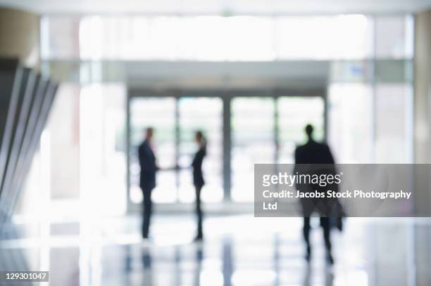 defocused businesspeople in office lobby - handshake silhouette stock pictures, royalty-free photos & images