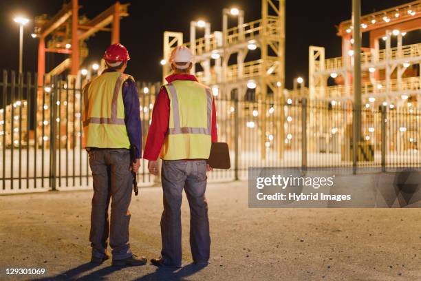 workers standing together in shipyard - reflective clothing at night stock pictures, royalty-free photos & images