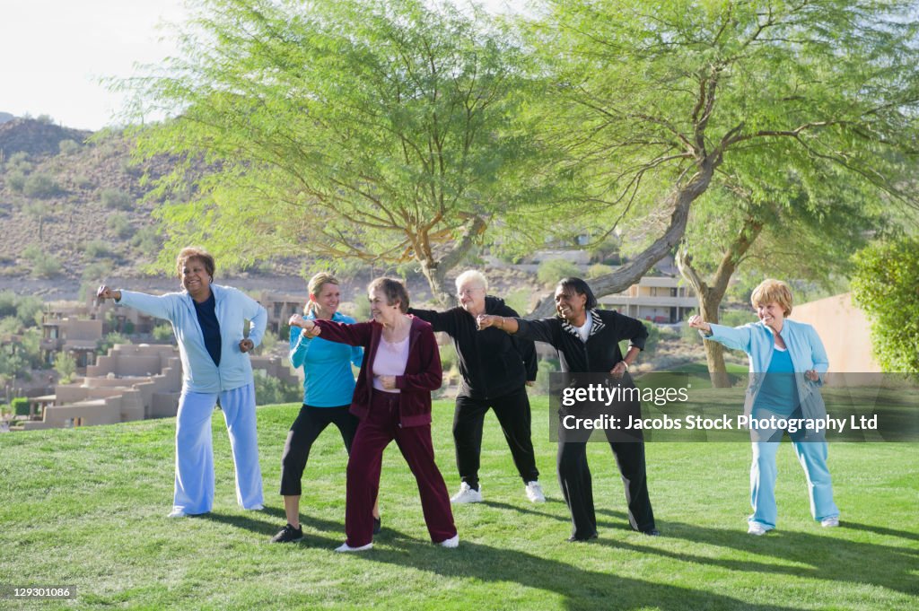 Women taking exercise class outdoors